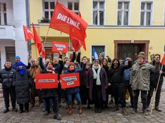 Ein Gruppenfoto mit ca 30 Mitgliedern der LINKEN. Neukölln mit Fahnen und Schildern "Vergesellschaftung jetzt"